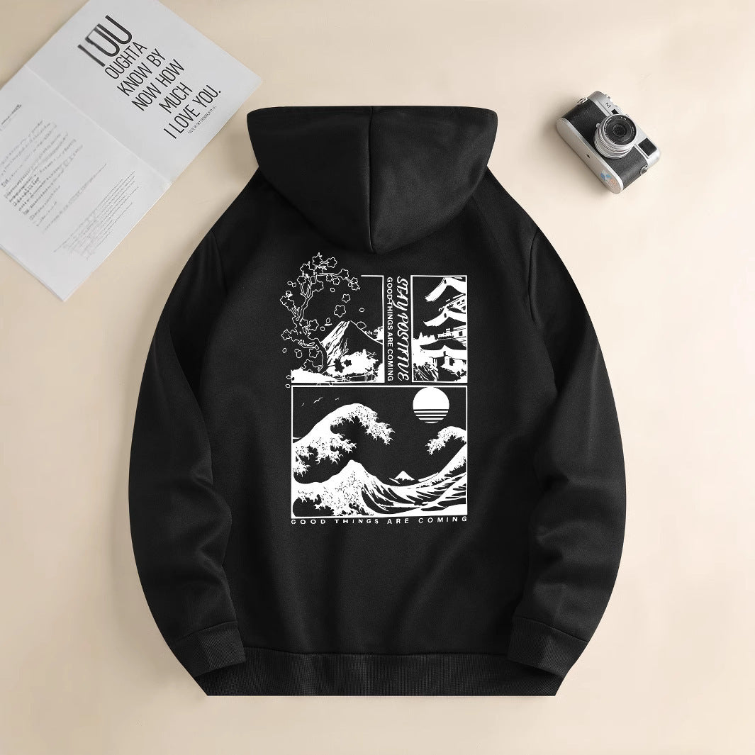 Black hoodie with white graphic design on a beige surface