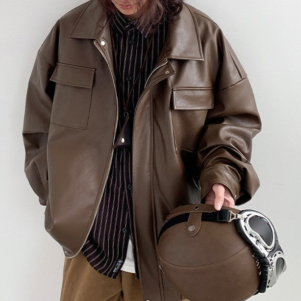 Person wearing a brown leather jacket holding a matching bag against a white background