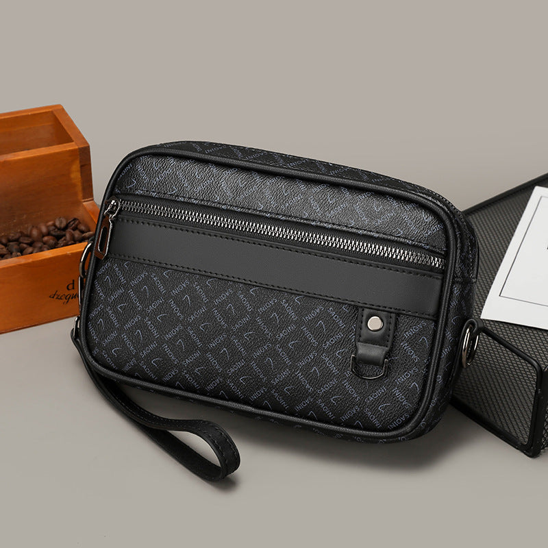 Black patterned bag with a strap on a light gray surface