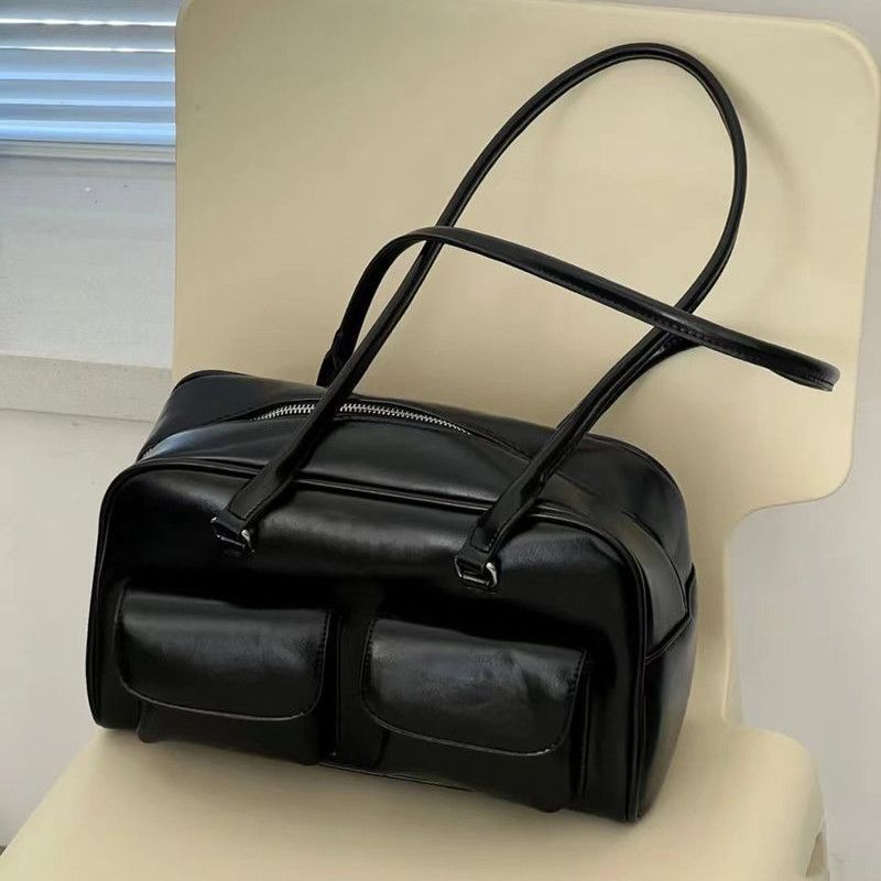 Black leather bag on a beige chair