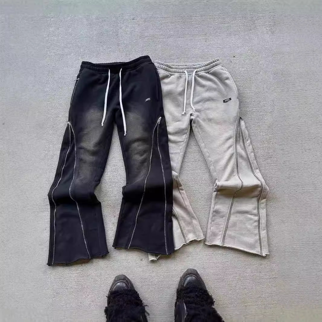 Two pairs of pants, one black and one b, on a gray surface.