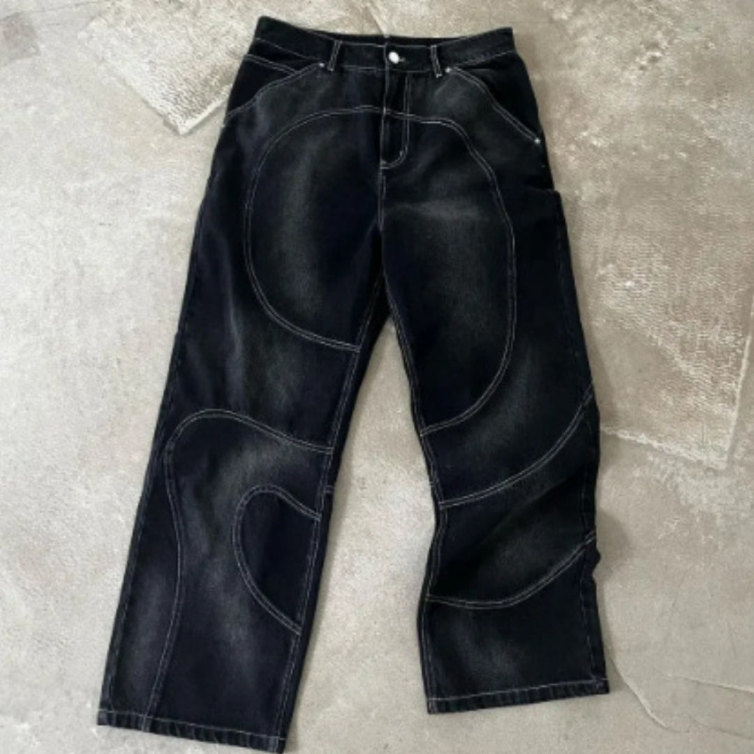 Black leather pants on a textured gray surface