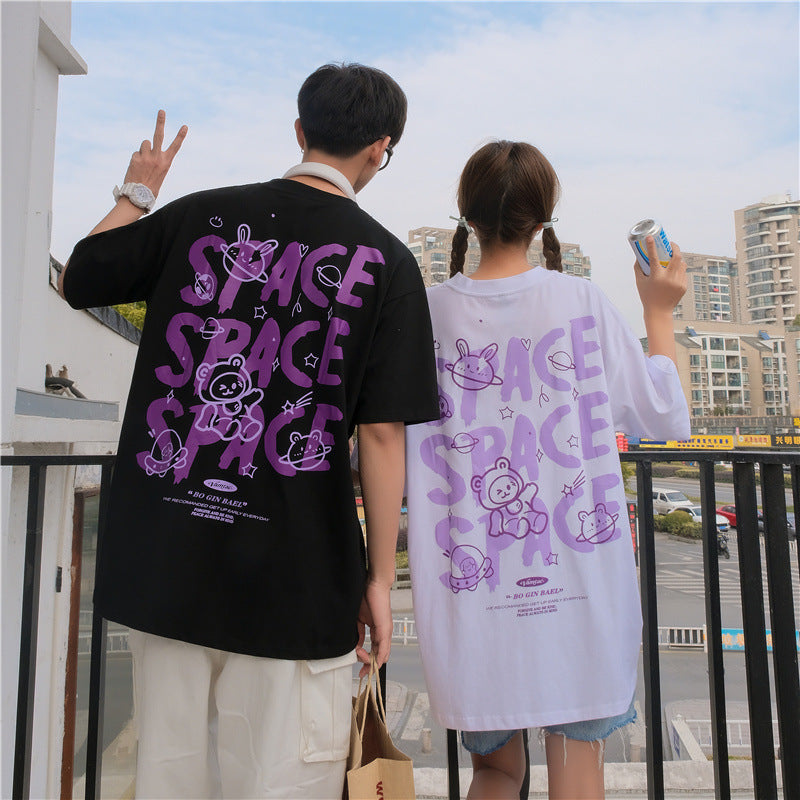 Two people wearing t-shirts with 'SPACE' printed on them, standing outdoors.