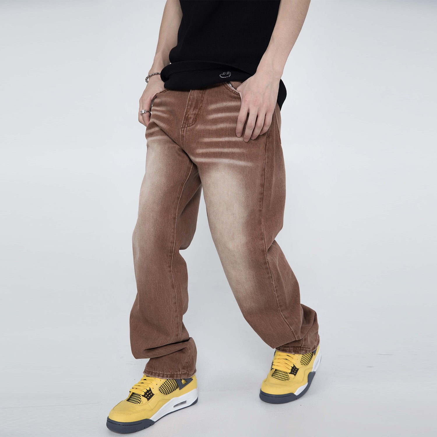 Person wearing brown pants and yellow sneakers on a white background