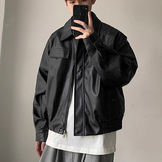 Person wearing a black jacket against a plain background